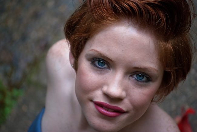 young attractive woman with red hair, fair skin, blue eyes