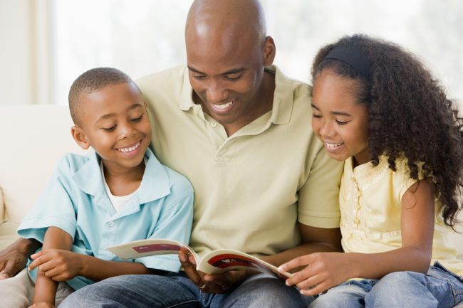Melanoma in People with Darker Skin man reading book to son and daughter